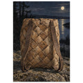 Woven birch bark backpack with brown straps on rocks, with dark conifers and a moonlit lake behind it.