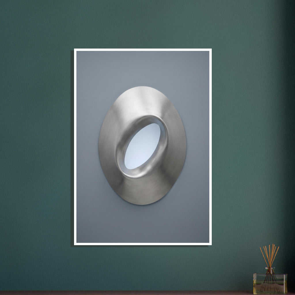 Brushed silver oval ring with a tilted opening, soft highlights and shadows against a blue-grey background.