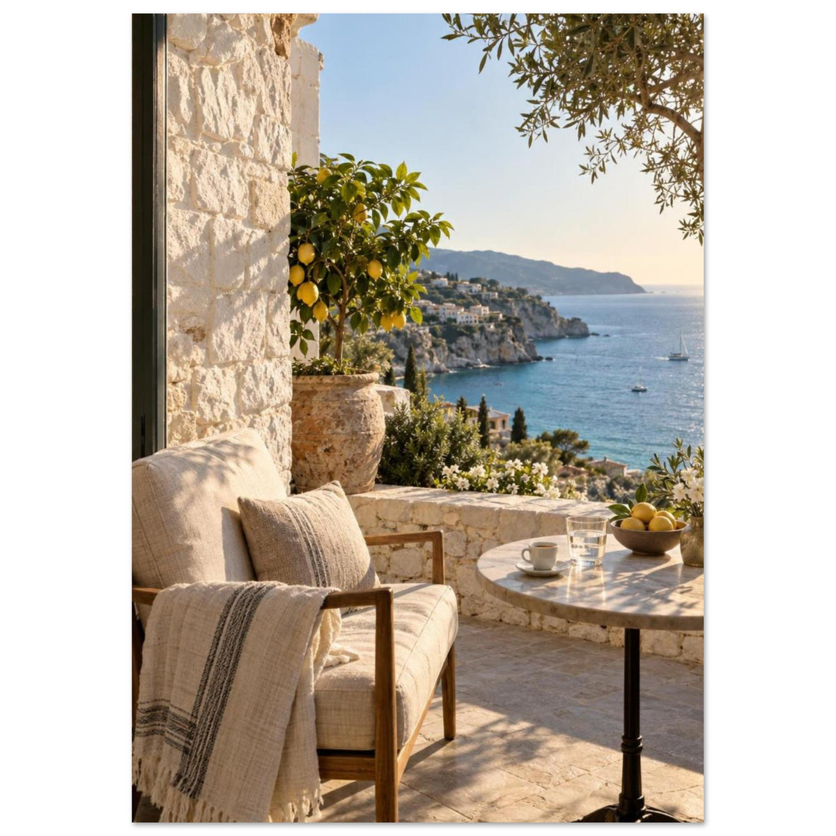 Lemon tree on a stone terrace with a cushioned chair, round table and blue sea overlooking a rocky coastline.