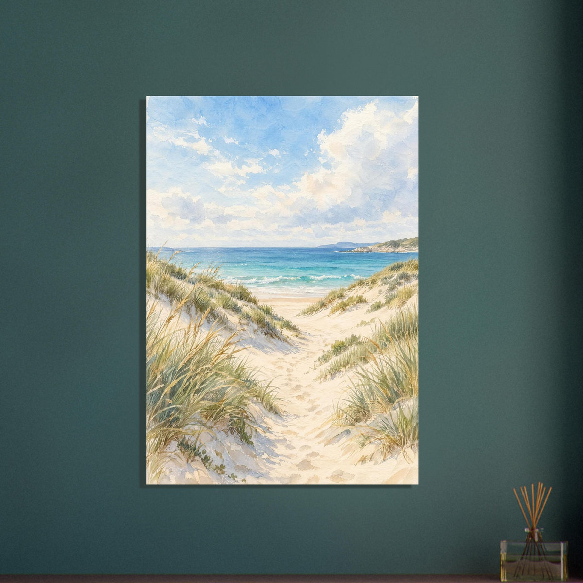 Sand dunes with grasses and footprints leading to turquoise waves beneath a blue sky with soft white clouds.