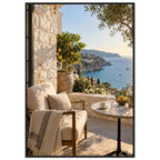 Lemon tree on a stone terrace with a cushioned chair, round table and blue sea overlooking a rocky coastline.