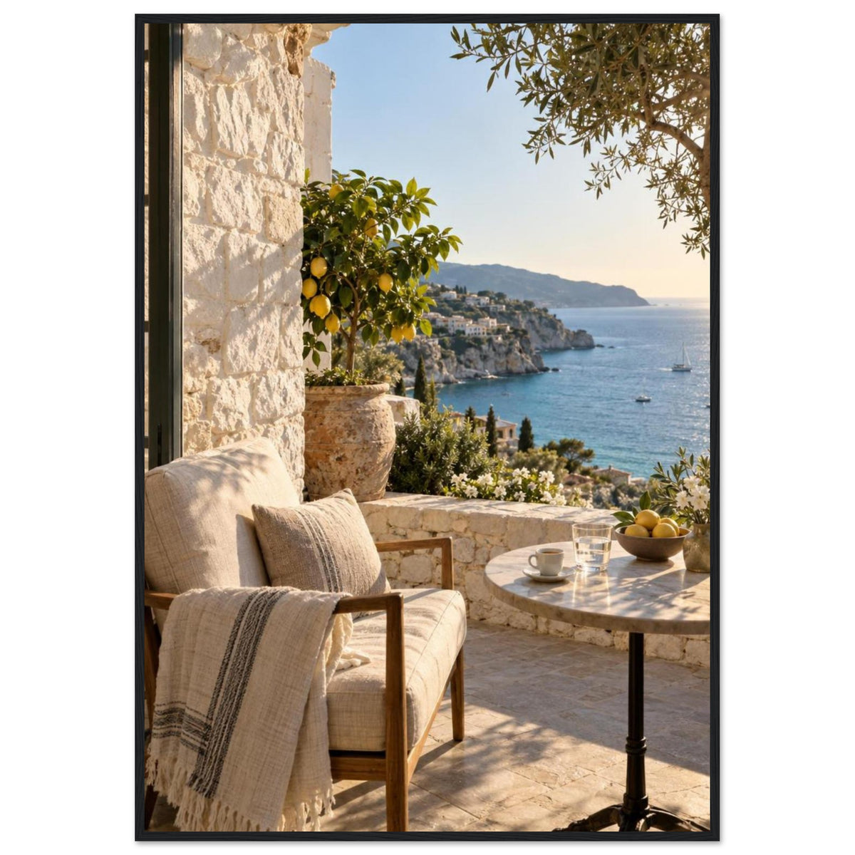 Lemon tree on a stone terrace with a cushioned chair, round table and blue sea overlooking a rocky coastline.