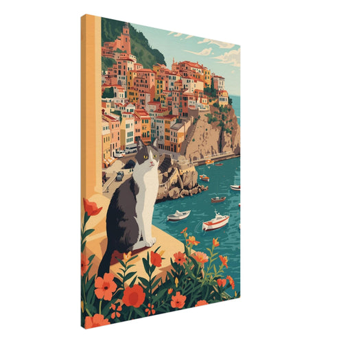 Grey and white cat on a flower-lined ledge above a teal harbour, small boats and colourful hillside buildings.