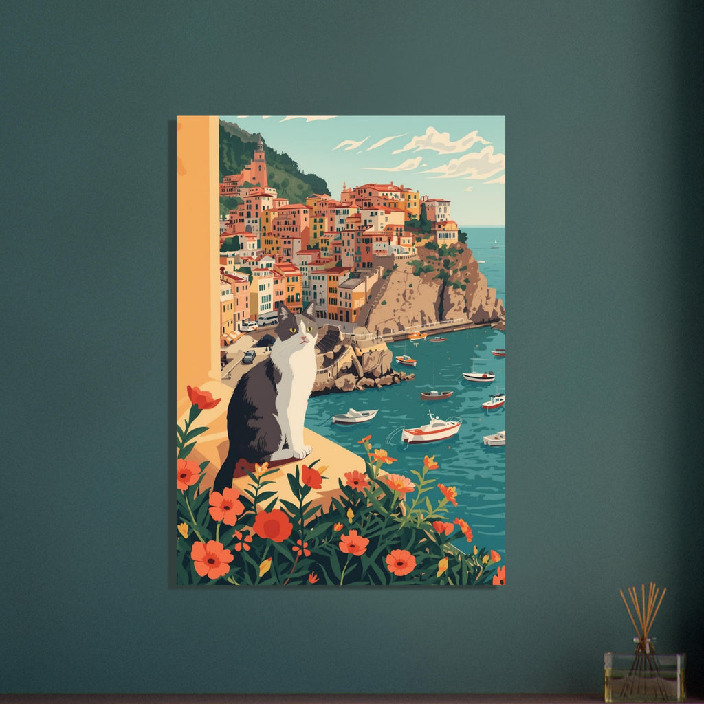 Grey and white cat on a flower-lined ledge above a teal harbour, small boats and colourful hillside buildings.