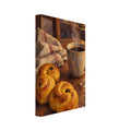 Golden curled buns beside a steaming mug on a wooden table, with a striped cloth, lit candle and evergreen sprig.