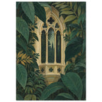 Ornate beige Gothic window with pointed arches and slender columns surrounded by large, layered dark green leaves.