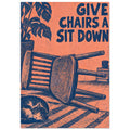 Wooden chair lying on its side beside a sleeping cat, with a plant and “Give Chairs A Sit Down” text in navy on coral.