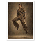 Suit in Suspension, a full-length model caught mid-jump in an oversized brown trouser suit against a sand-toned studio backgr