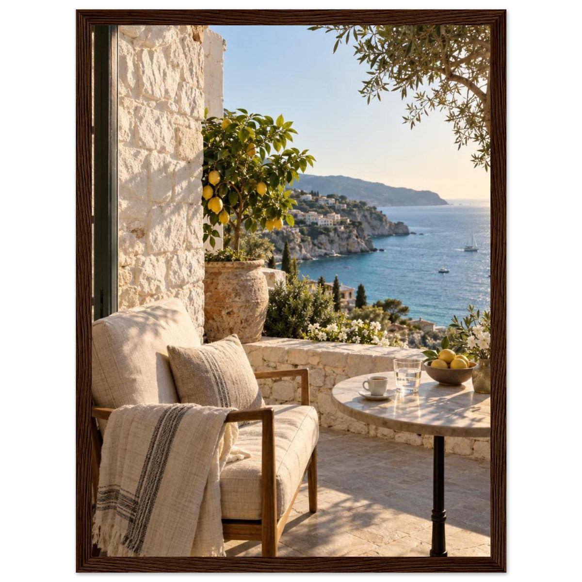 Lemon tree on a stone terrace with a cushioned chair, round table and blue sea overlooking a rocky coastline.
