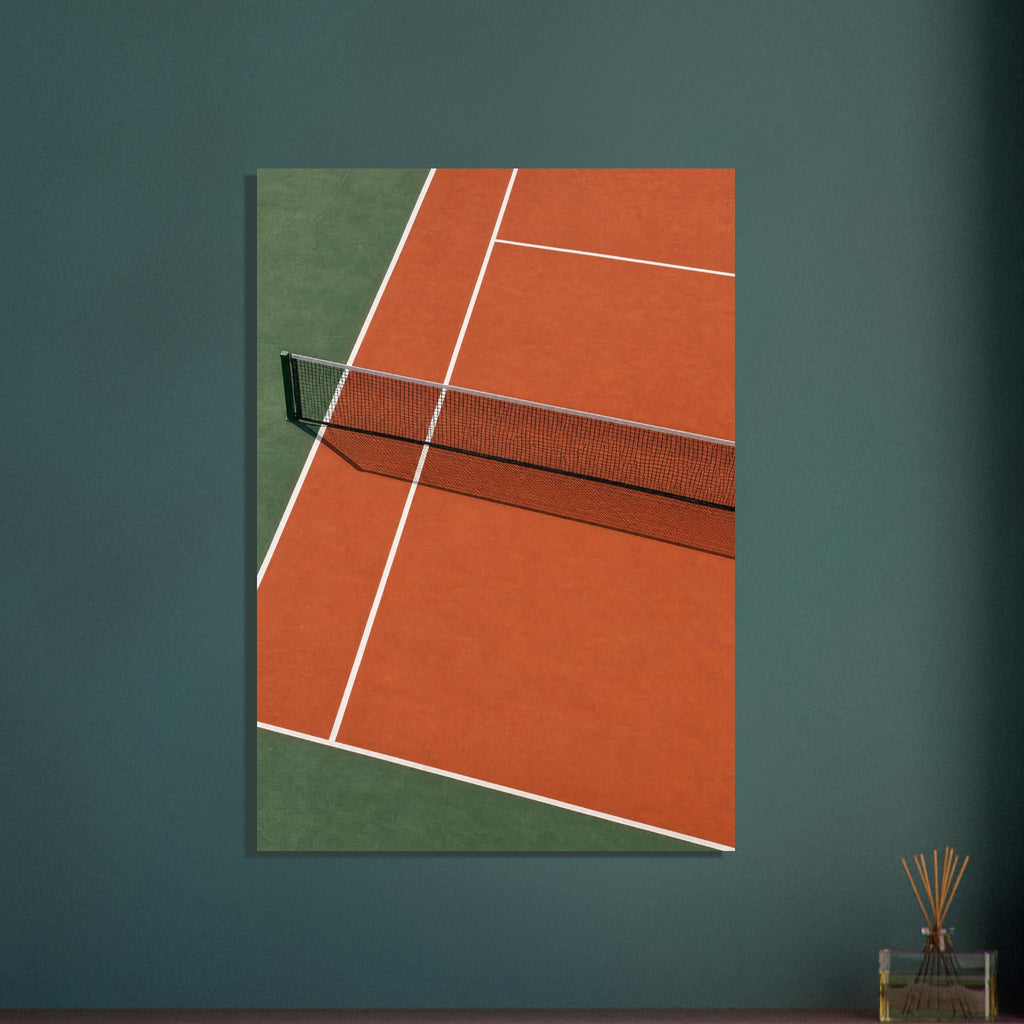 Tennis court viewed from above, with terracotta and green surfaces, white lines and a net casting a patterned shadow.