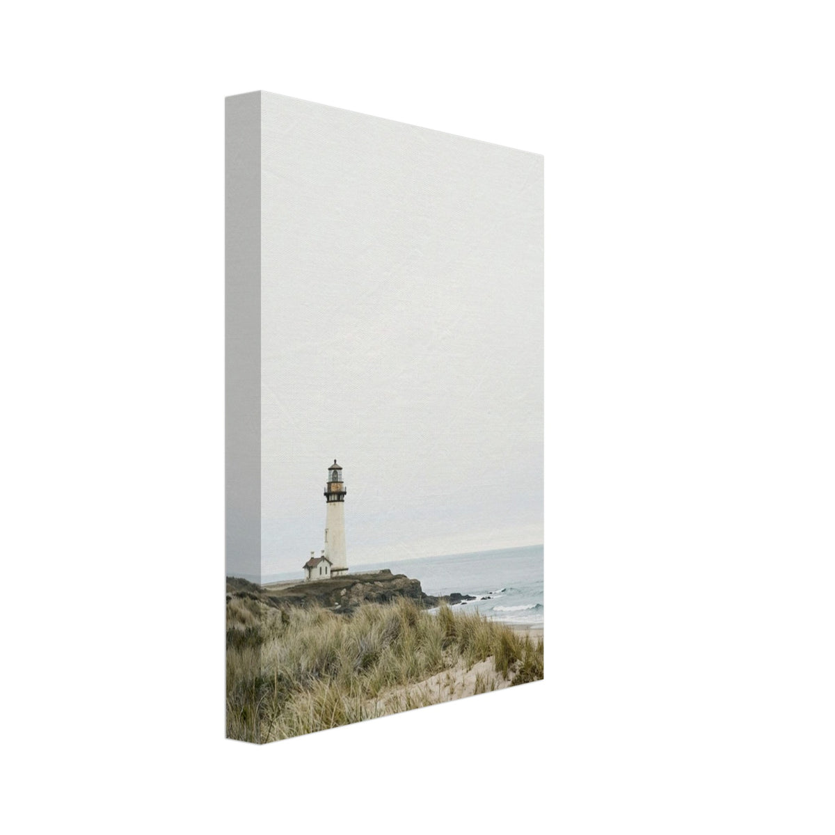 Lighthouse on a rocky headland beyond grassy sand dunes, with gentle waves and a wide, pale grey sky.