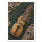 Wooden nyckelharpa on dark green cloth, surrounded by woodworking tools and curled wood shavings on a workbench.