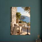 Lemon tree on a stone terrace with a cushioned chair, round table and blue sea overlooking a rocky coastline.