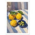 Three yellow lemons with green leaves beside a blue bowl of green olives on a pale striped surface with strong shadows.
