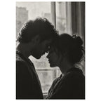 Black and white photograph of a couple touching foreheads beside a window, their profiles softly outlined by daylight.