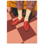 Red loafers and cream dotted socks on a chequered floor, with a black cat beneath a mustard armchair.