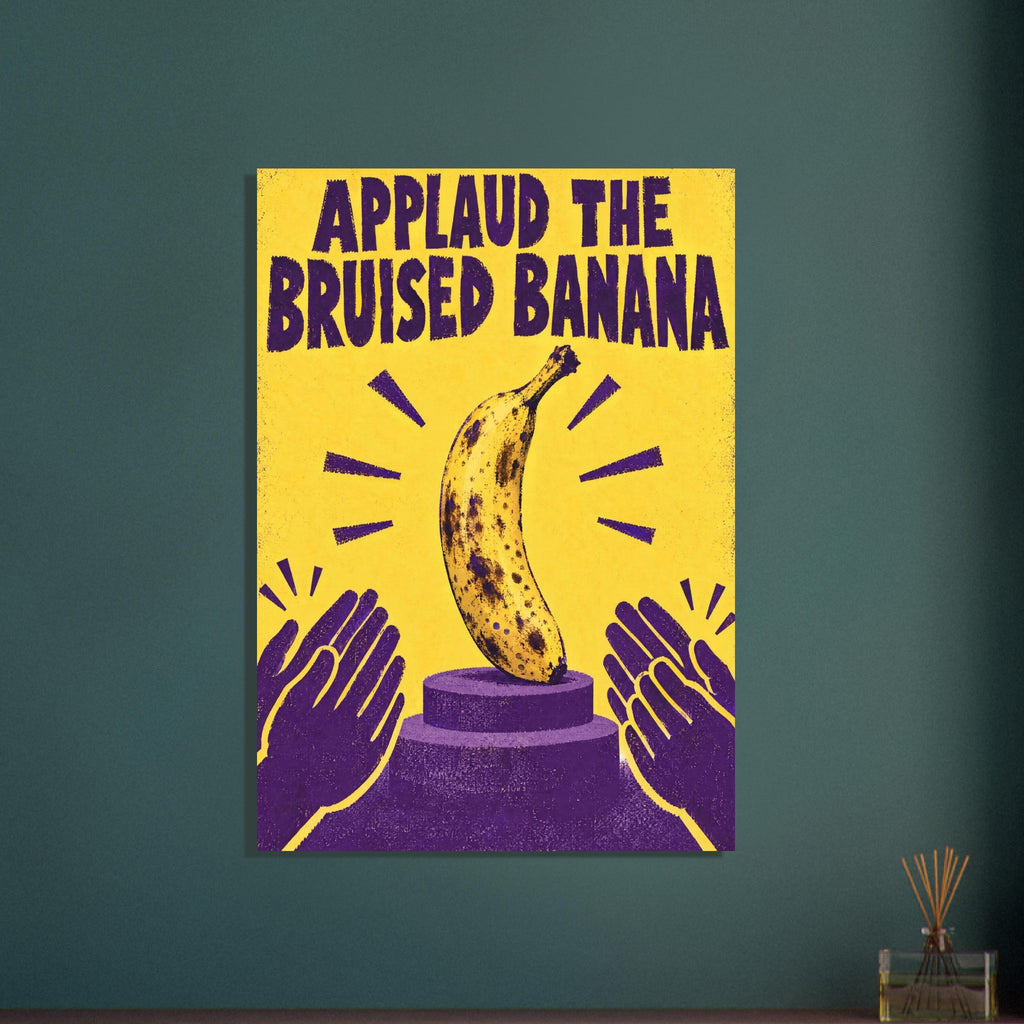 Bruised banana on a purple podium with clapping hands, a yellow background and the words ‘Applaud the Bruised Banana’.