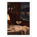 Train dining table with a coupe glass, glowing lamp and cream linen beside burgundy seating and a rain-streaked window.