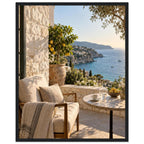 Lemon tree on a stone terrace with a cushioned chair, round table and blue sea overlooking a rocky coastline.