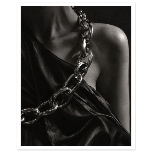 Oversized polished chain links cross dark, lustrous fabric beside a bare shoulder and neckline in black and white.