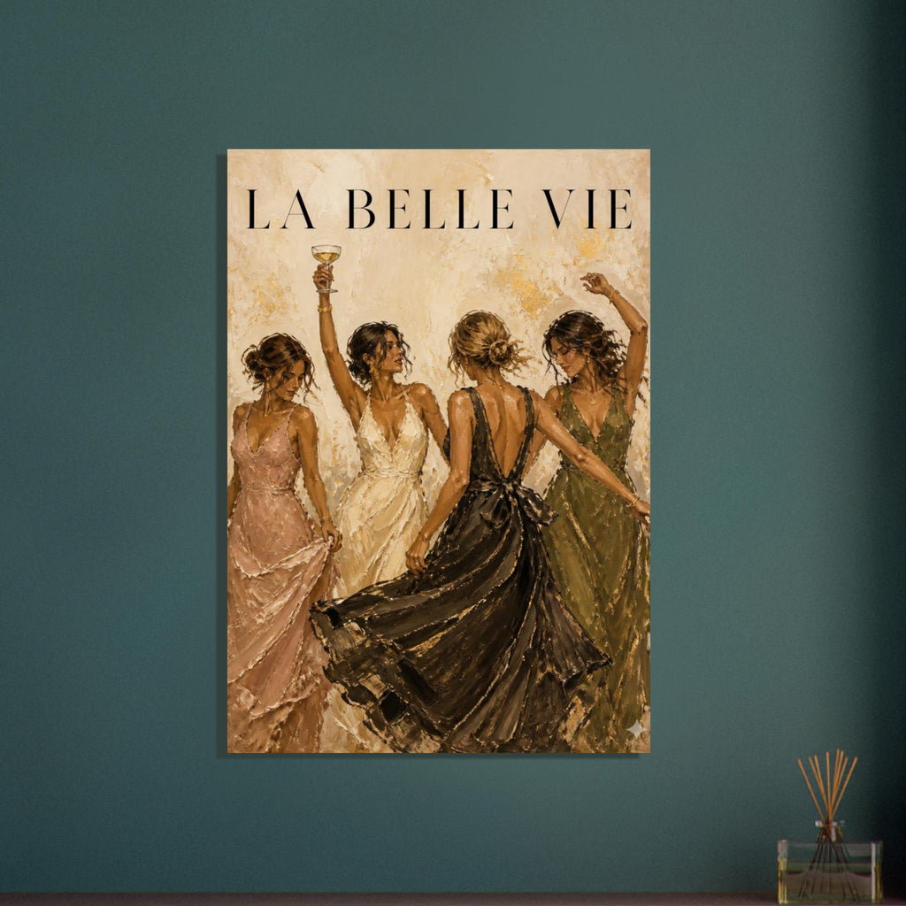 Four women in flowing evening dresses dancing beneath La Belle Vie lettering, one raising a glass, on a beige background.
