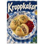 Kroppkakor dumplings with red berries on a blue patterned plate over gingham, beneath large cream Kroppkakor lettering.