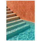 Stone steps descending into turquoise pool water beside a terracotta wall, with sunlight rippling across submerged stairs.
