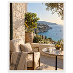 Lemon tree on a stone terrace with a cushioned chair, round table and blue sea overlooking a rocky coastline.