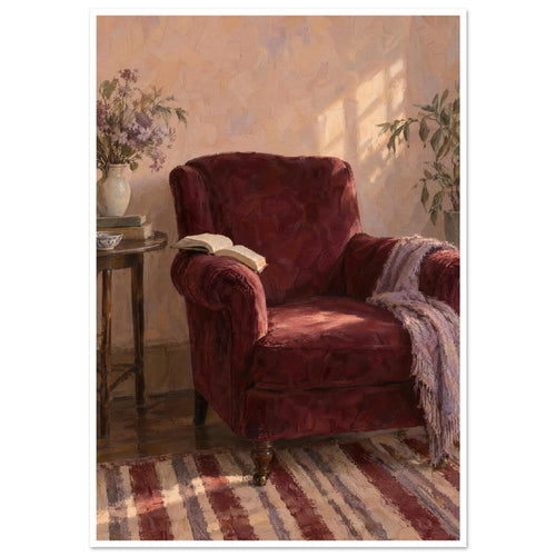 Burgundy armchair with an open book and lilac throw beside a table with flowers, books and a cup in a sunlit room.