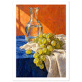 Green grapes on cream fabric beside a glass carafe of water, with a blue tabletop and textured orange background.