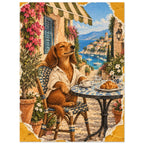 Golden-brown dog in a cream shirt at a café table with coffee and a croissant, overlooking a flower-lined harbour.