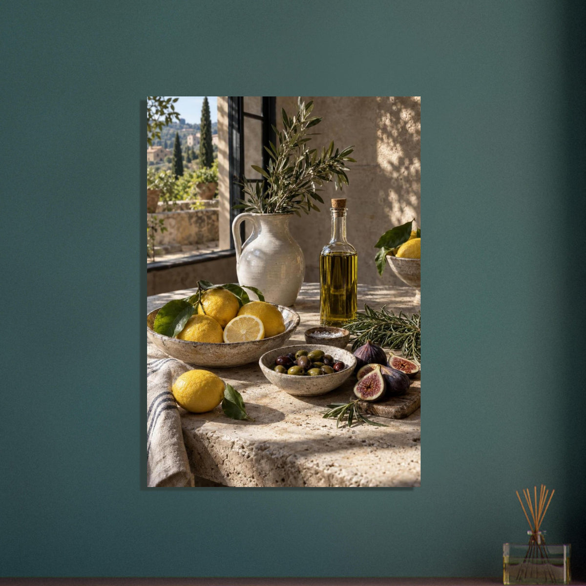 Lemons, olives, figs and a bottle of oil on a stone table beside a ceramic jug of leafy branches and a sunlit window.