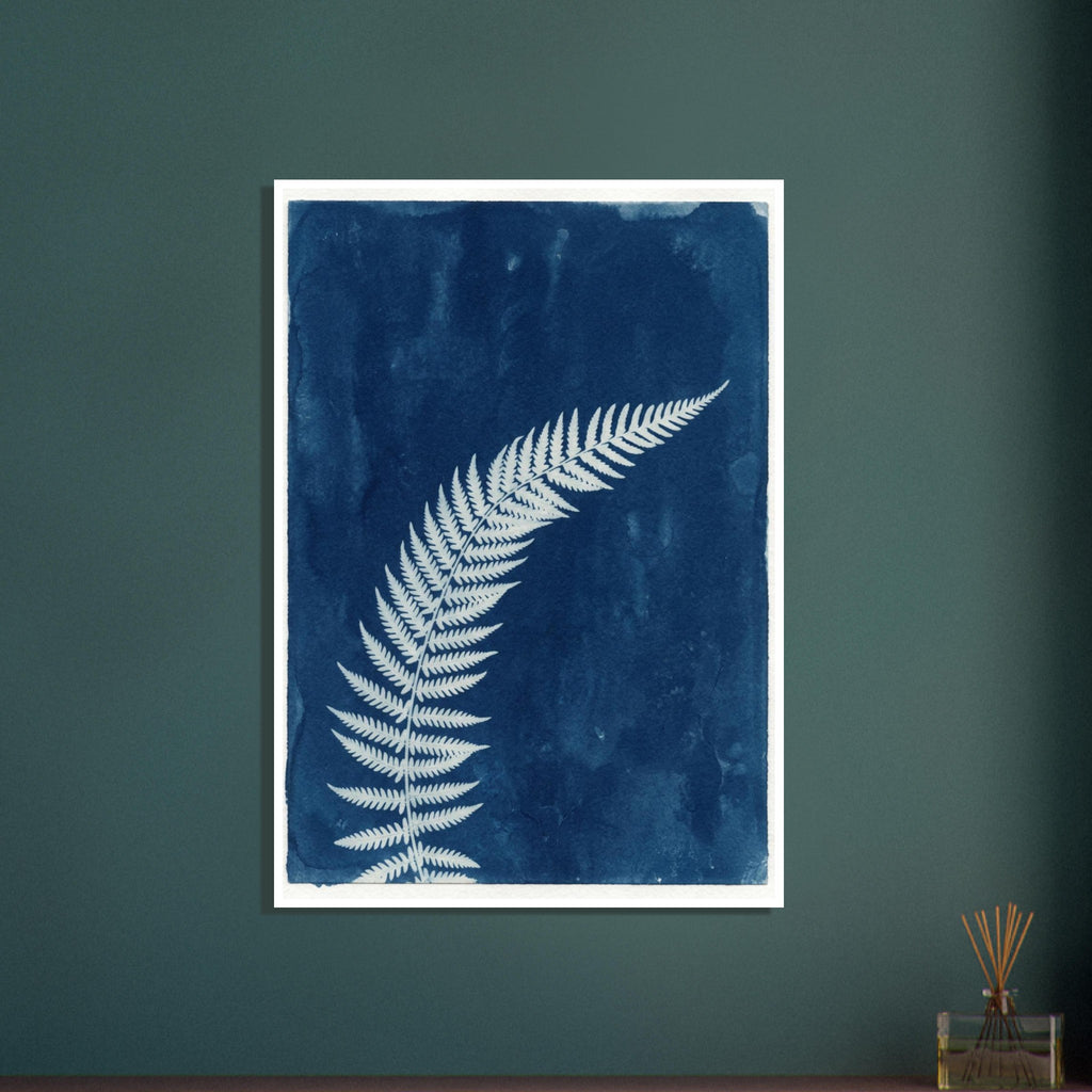Pale fern frond curving diagonally across a textured deep blue background with a narrow off-white border.