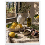 Lemons, olives, figs and a bottle of oil on a stone table beside a ceramic jug of leafy branches and a sunlit window.
