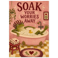 Frog in a shower cap relaxing in a pink bubble bath beneath ‘Soak Your Worries Away’ lettering, with a yellow bath duck.