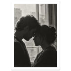 Black and white photograph of a couple touching foreheads beside a window, their profiles softly outlined by daylight.