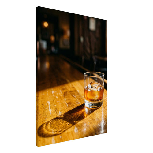 Tumbler of amber drink with ice on a sunlit wooden bar, casting a long shadow against a dark, blurred interior.