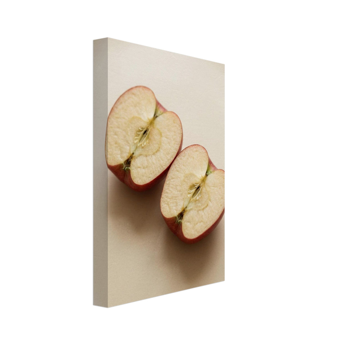 Two red-skinned apple halves with exposed cores on a beige surface, with soft shadows and ample empty space above.