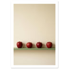 Four red apples in a row on a muted green ledge against a textured cream wall with ample empty space above.