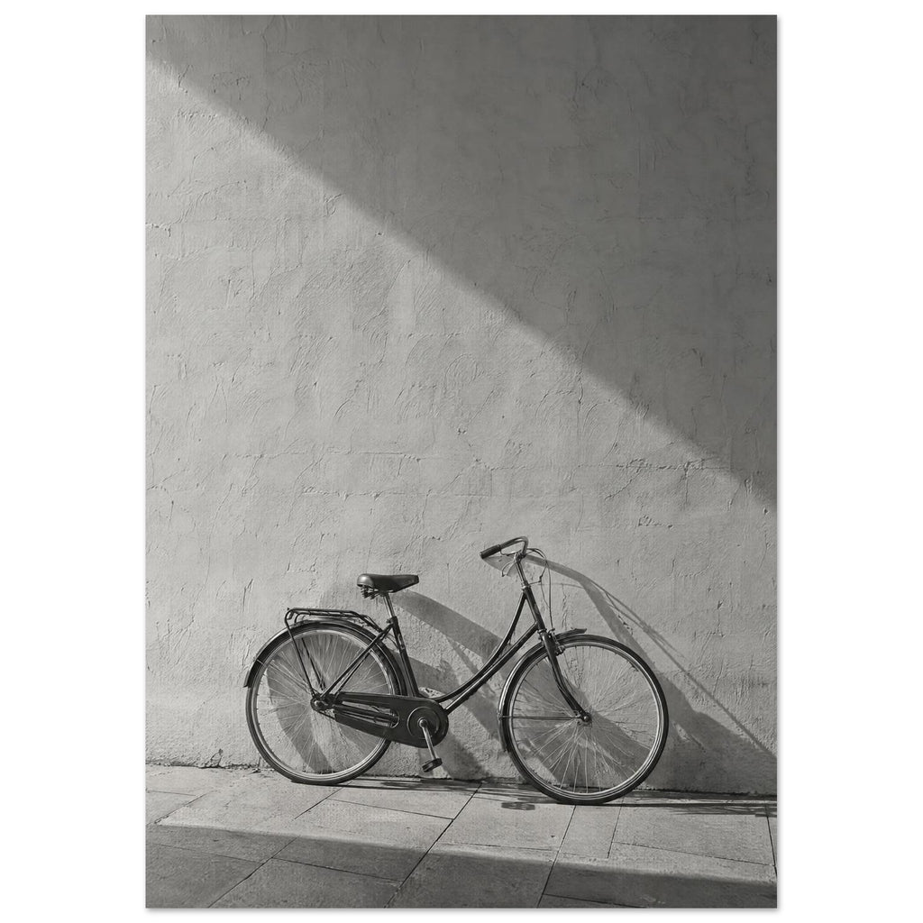 Bicycle leaning against a textured wall, with diagonal sunlight and long shadows across the wall and pavement.