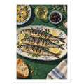 Three grilled fish with lemon and herbs on a patterned platter, with olives, potatoes and bread on a green table.