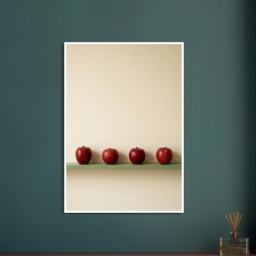 Four red apples in a row on a muted green ledge against a textured cream wall with ample empty space above.