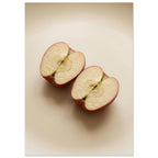 Two red-skinned apple halves with exposed cores on a beige surface, with soft shadows and ample empty space above.