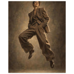 Suit in Suspension, a full-length model caught mid-jump in an oversized brown trouser suit against a sand-toned studio backgr