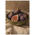 Purple figs, one halved, in an olive-green bowl on folded cream cloth against a brown, visibly brushworked background.