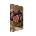 Purple figs, one halved, in an olive-green bowl on folded cream cloth against a brown, visibly brushworked background.