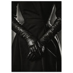Overlapping hands in long black leather gloves against a dark fitted outfit, photographed in black and white.