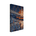 Riverside bonfire beside a bridge with small figures, reflected in angular navy, orange and cream shapes on the water.