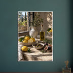 Lemons, olives, figs and a bottle of oil on a stone table beside a ceramic jug of leafy branches and a sunlit window.
