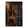 Wooden woven chair draped with a patterned blue fringed throw, painted in warm light against a dark brown interior.